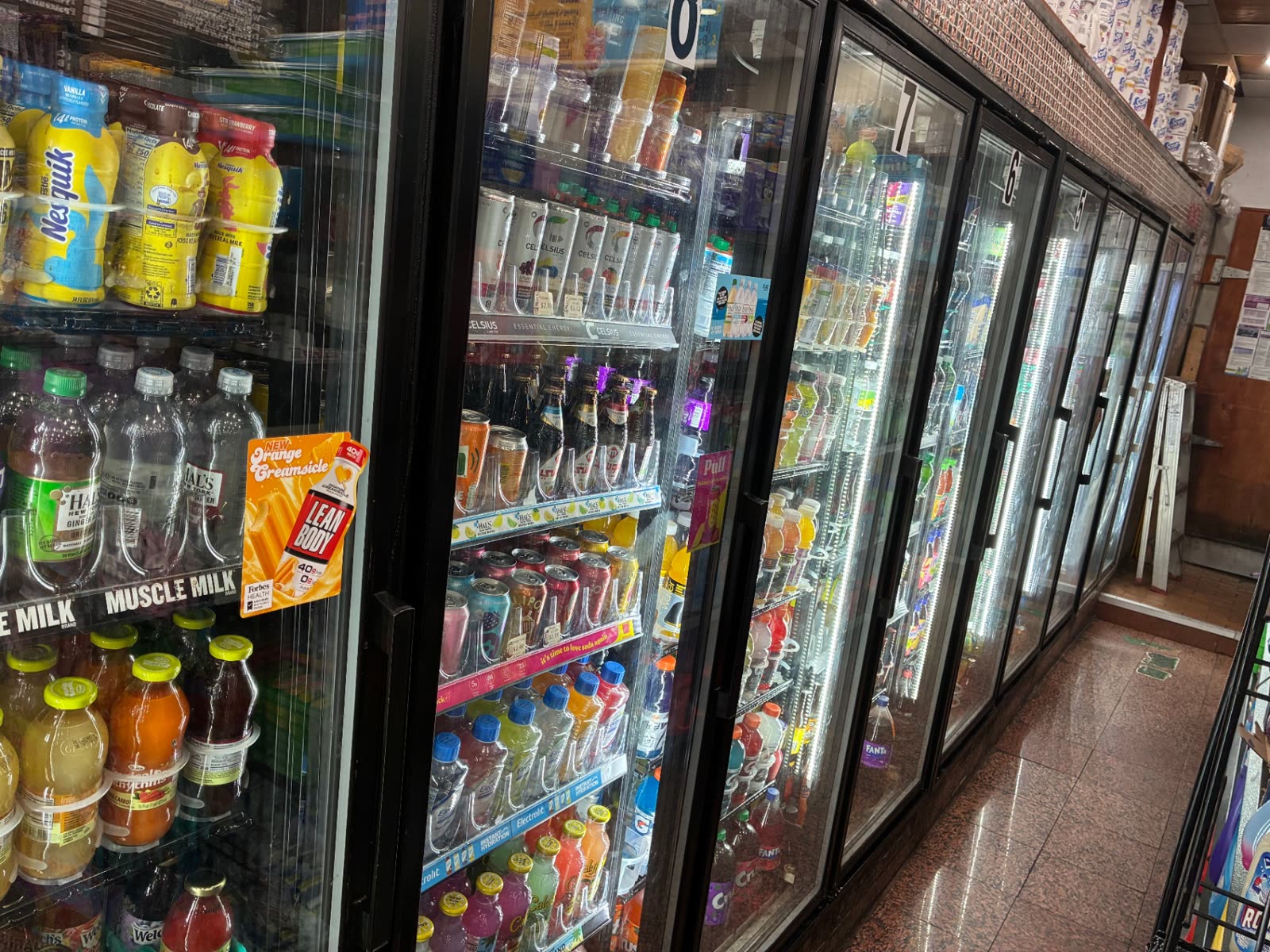 Refrigerated cases of cold drinks inside The Famous Deli